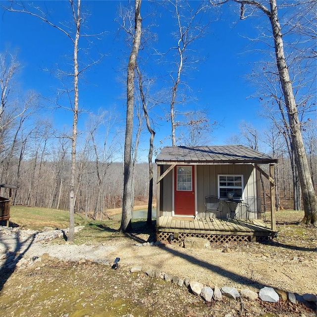 1432 Wayne 523, Wappapello, MO 63966 - view of front of house featuring board and batten siding, an outdoor structure, and a forest view