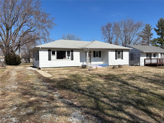 rear view of house featuring a lawn and a porch