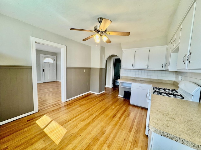 922 S 6th St, Belleville, IL 62220 - kitchen with white gas stove, arched walkways, light countertops, ceiling fan, and light wood finished floors