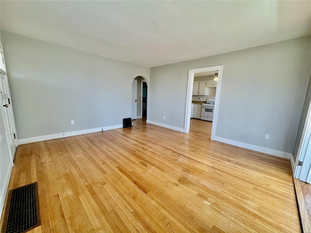 922 S 6th St, Belleville, IL 62220 - unfurnished bedroom with arched walkways, light wood-style flooring, and baseboards