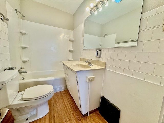 922 S 6th St, Belleville, IL 62220 - bathroom featuring toilet, wood finished floors, shower / bathtub combination, vanity, and decorative backsplash