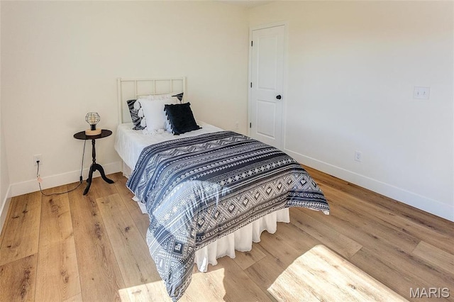 bedroom with baseboards and wood finished floors