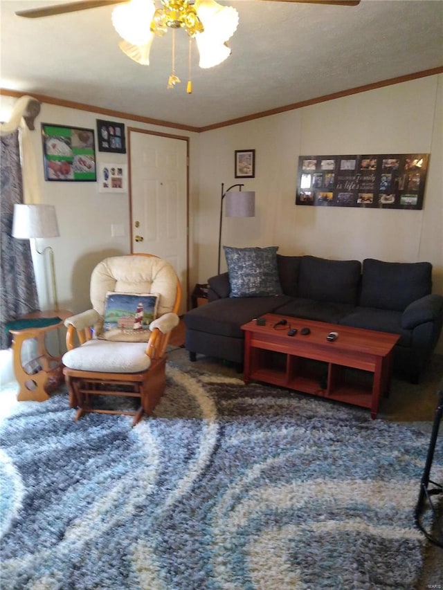 living room featuring a ceiling fan, ornamental molding, and carpet