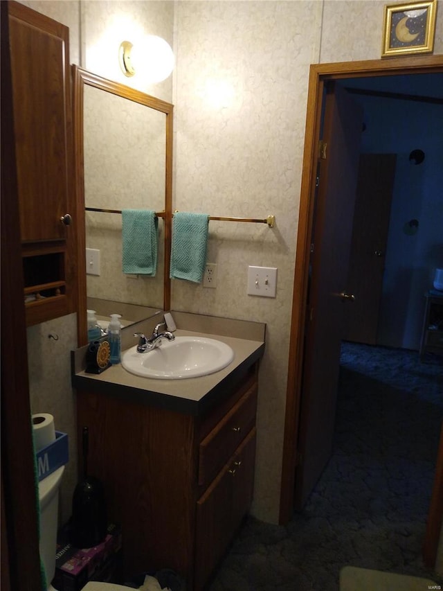 half bath featuring vanity and toilet