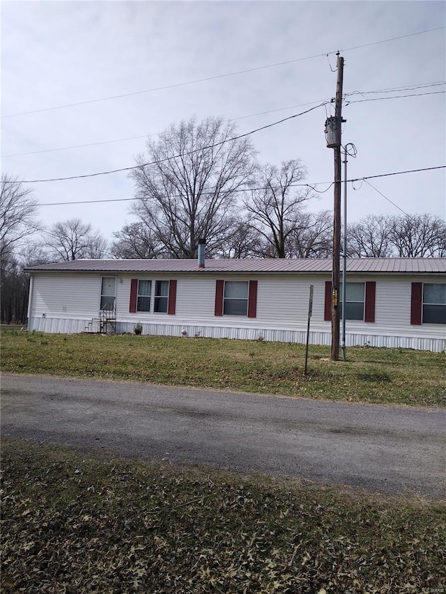 manufactured / mobile home with a front yard and metal roof