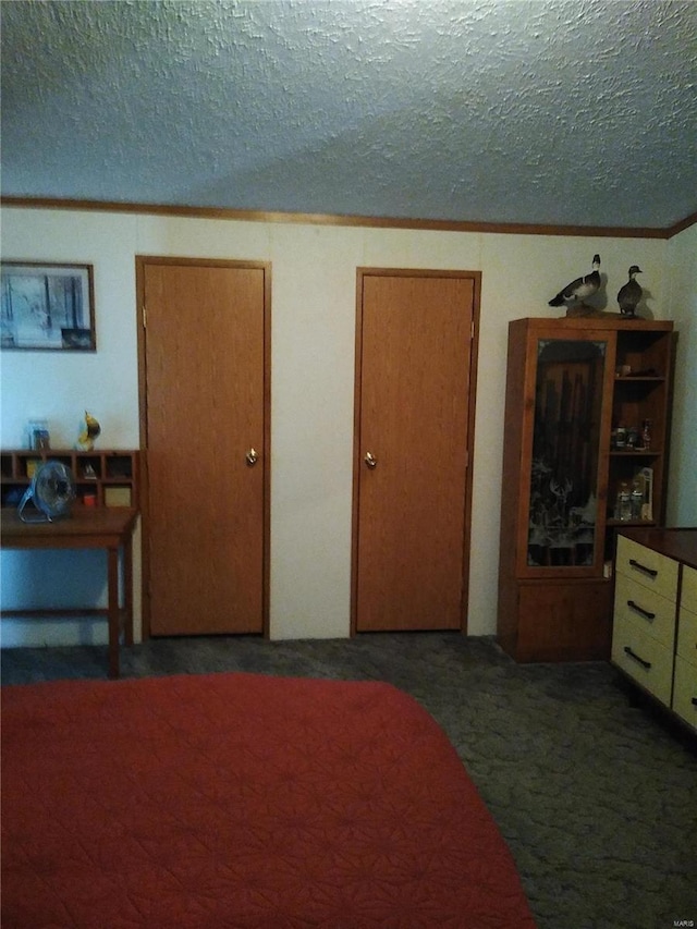 bedroom featuring crown molding, a textured ceiling, and carpet
