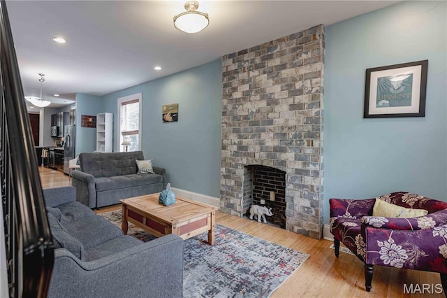 2244 Nebraska Ave, Saint Louis, MO 63104 - living room featuring wood-type flooring, a brick fireplace, and recessed lighting