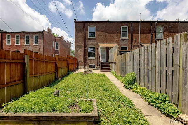 2244 Nebraska Ave, Saint Louis, MO 63104 - rear view of property featuring a fenced backyard, a garden, and brick siding