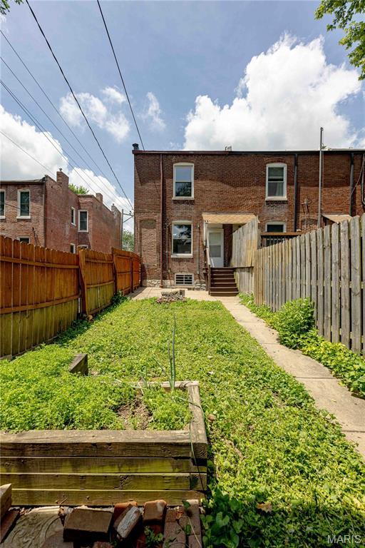2244 Nebraska Ave, Saint Louis, MO 63104 - rear view of property featuring a fenced backyard, entry steps, and a garden