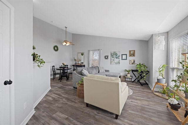 living area featuring lofted ceiling, dark wood-style floors, baseboards, and a ceiling fan