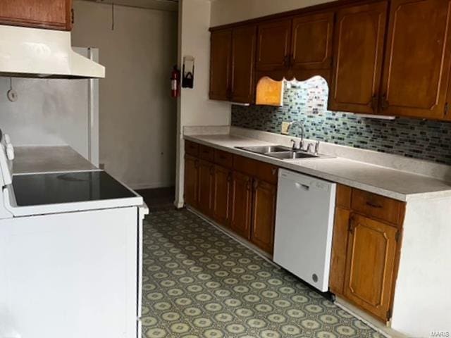 kitchen featuring white appliances, under cabinet range hood, light floors, a sink, and tasteful backsplash