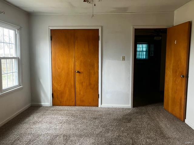unfurnished bedroom featuring carpet flooring and baseboards