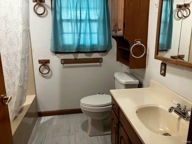 bathroom with toilet, vanity, and baseboards