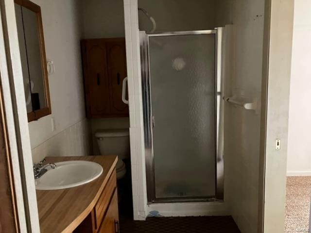 full bath with a stall shower, vanity, and toilet