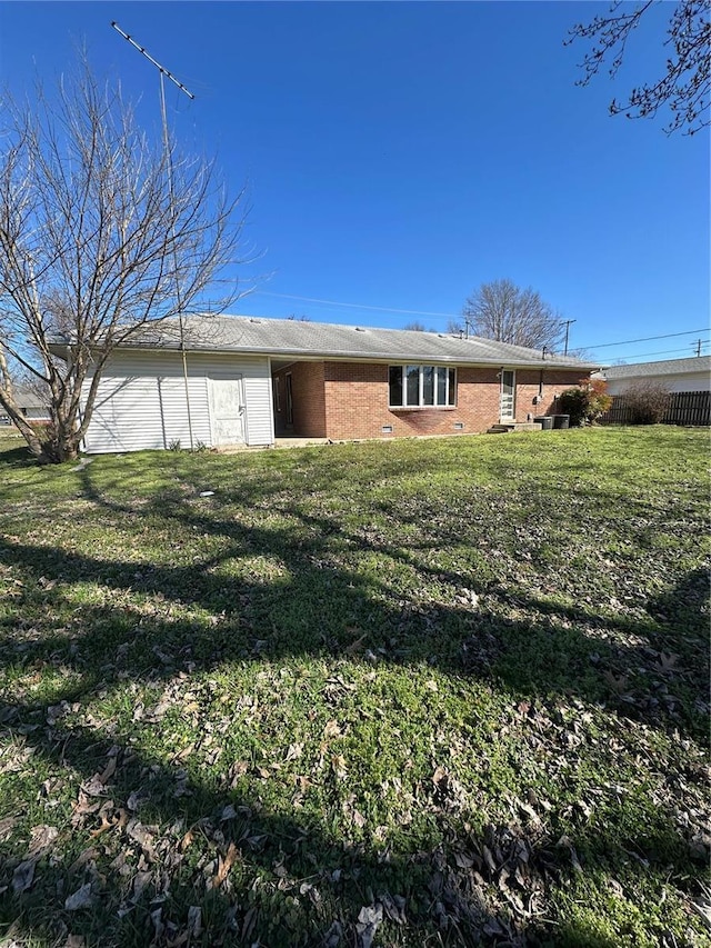 rear view of property featuring brick siding and a yard