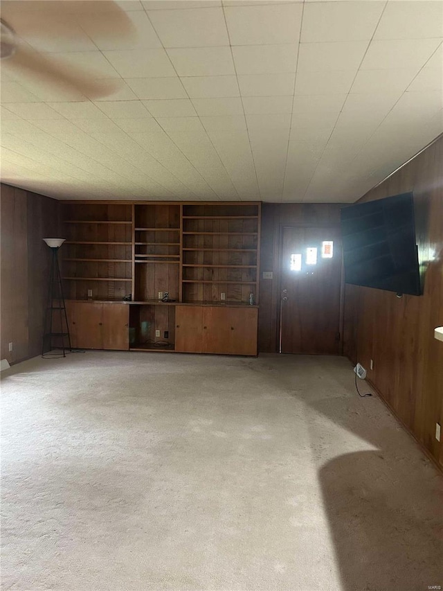 basement featuring wood walls and carpet flooring