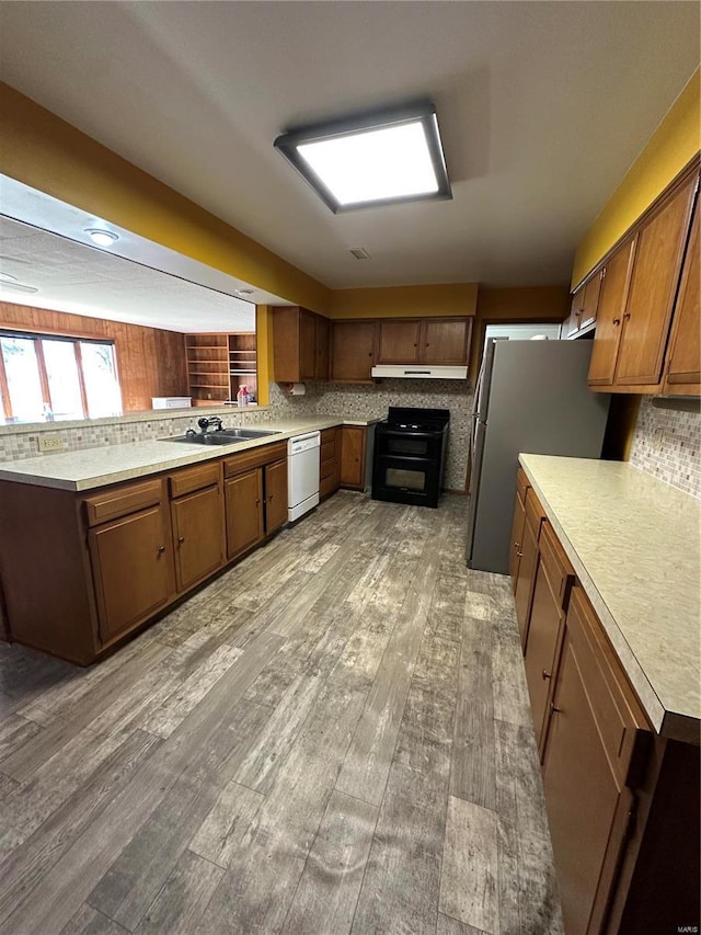 kitchen with dishwasher, light wood-style floors, range, and freestanding refrigerator