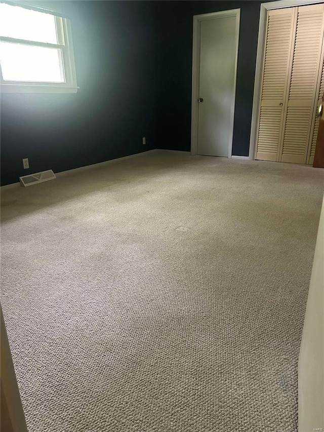 unfurnished bedroom featuring carpet and a closet