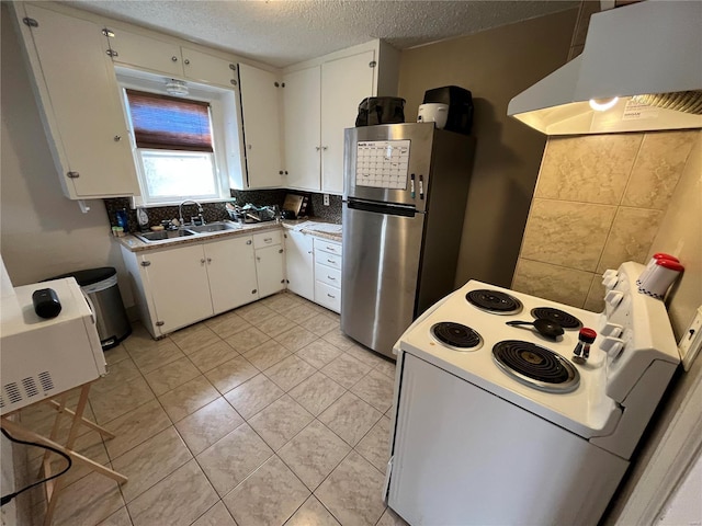 kitchen featuring white range with electric cooktop, under cabinet range hood, freestanding refrigerator, a sink, and white cabinets