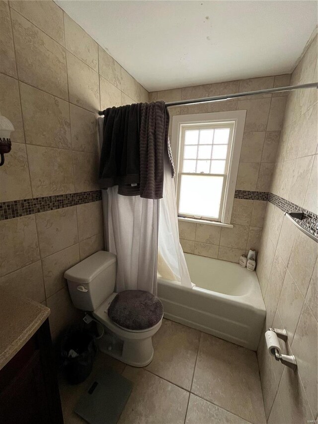 bathroom with tile patterned floors, tile walls, toilet, and shower / bath combination with curtain