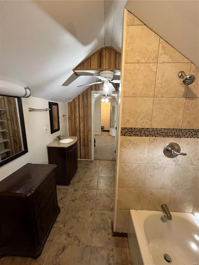 bathroom with vaulted ceiling, ceiling fan, vanity, and tub / shower combination