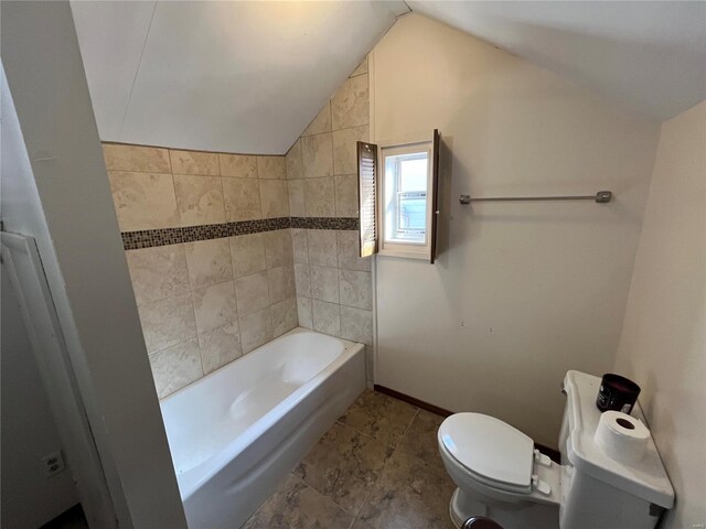 bathroom featuring vaulted ceiling, toilet, baseboards, and  shower combination