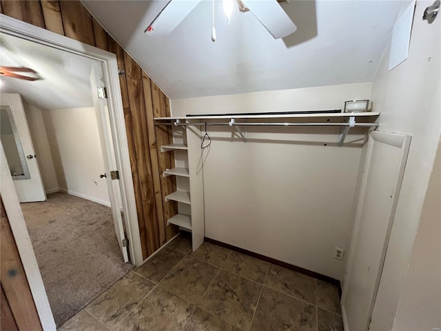 spacious closet with vaulted ceiling, ceiling fan, and dark carpet