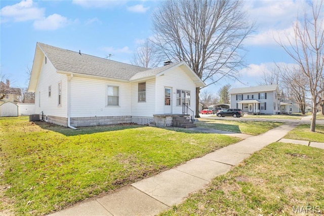533 Locust St, Carrollton, IL 62016 - view of property exterior featuring cooling unit, a yard, a shingled roof, and a chimney