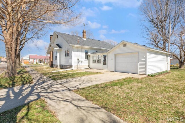 533 Locust St, Carrollton, IL 62016 - view of front of property featuring a chimney, concrete driveway, a front yard, and a garage