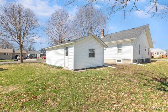 533 Locust St, Carrollton, IL 62016 - rear view of house featuring central AC unit, a chimney, and a yard