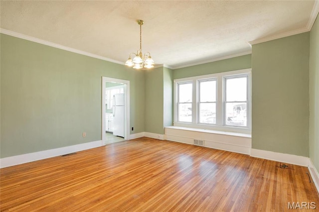 533 Locust St, Carrollton, IL 62016 - empty room featuring a chandelier, wood finished floors, baseboards, and crown molding
