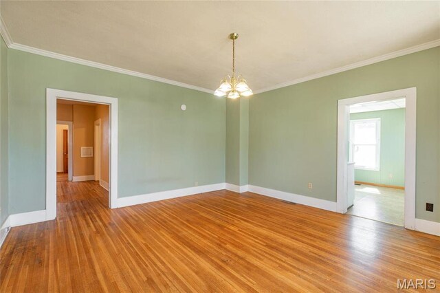 533 Locust St, Carrollton, IL 62016 - empty room featuring crown molding, a chandelier, baseboards, and wood finished floors