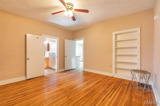 533 Locust St, Carrollton, IL 62016 - unfurnished room featuring light wood-style floors, a ceiling fan, built in features, and baseboards