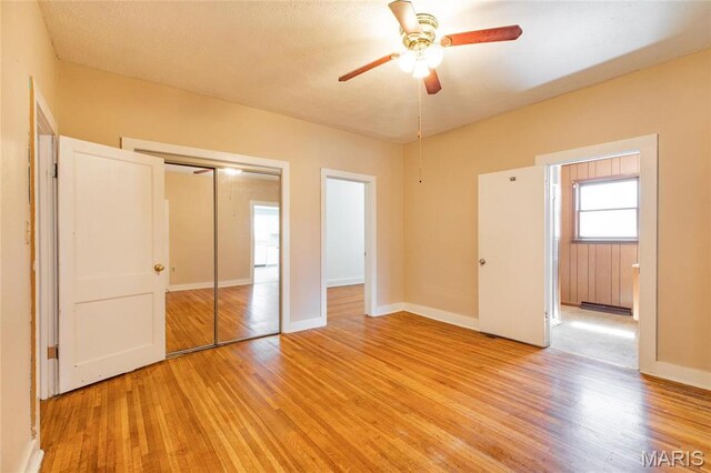 533 Locust St, Carrollton, IL 62016 - unfurnished bedroom featuring light wood finished floors, a closet, baseboards, and a ceiling fan