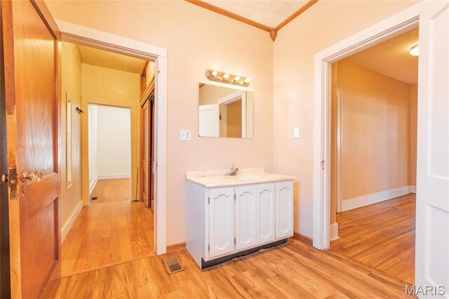533 Locust St, Carrollton, IL 62016 - bathroom featuring wood finished floors, vanity, baseboards, and ornamental molding