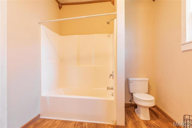 533 Locust St, Carrollton, IL 62016 - full bath featuring wood finished floors, toilet, shower / tub combination, and baseboards