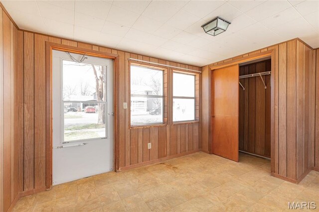 533 Locust St, Carrollton, IL 62016 - unfurnished bedroom with wood walls, light floors, and a closet