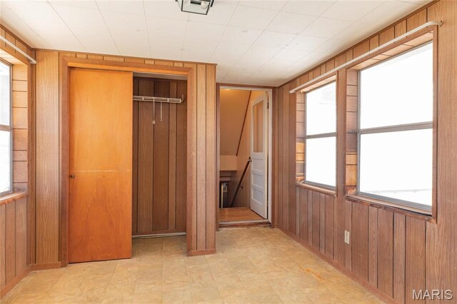 533 Locust St, Carrollton, IL 62016 - unfurnished bedroom with light flooring, wood walls, and a closet
