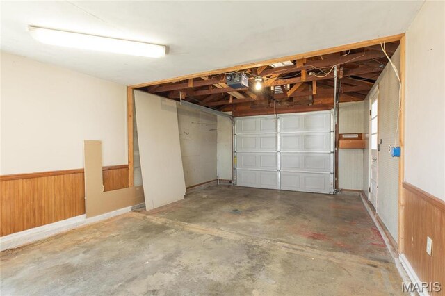 533 Locust St, Carrollton, IL 62016 - garage featuring a garage door opener, a wainscoted wall, and wood walls