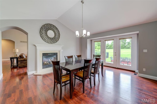 322 Gerard Ln, Moscow Mills, MO 63362 - dining space featuring a glass covered fireplace, dark wood-style floors, lofted ceiling, baseboards, and arched walkways