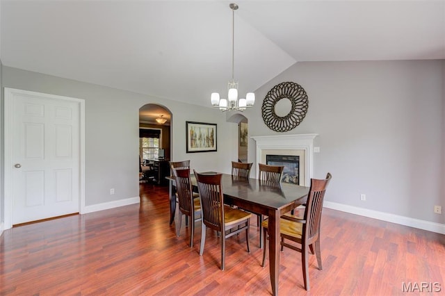322 Gerard Ln, Moscow Mills, MO 63362 - dining area featuring arched walkways, vaulted ceiling, wood finished floors, baseboards, and a chandelier