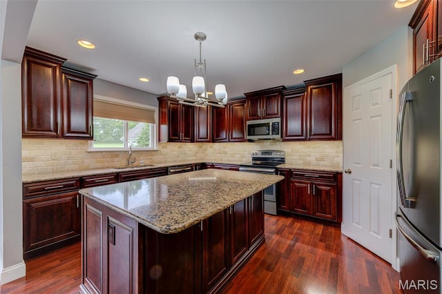 322 Gerard Ln, Moscow Mills, MO 63362 - kitchen with stainless steel appliances, dark brown cabinets, dark wood-type flooring, a sink, and a chandelier