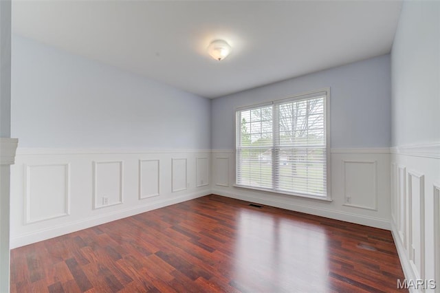 322 Gerard Ln, Moscow Mills, MO 63362 - empty room featuring a wainscoted wall, a decorative wall, and dark wood-style flooring