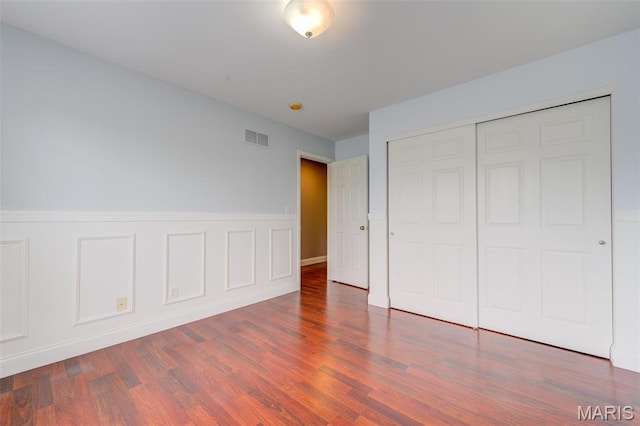 322 Gerard Ln, Moscow Mills, MO 63362 - unfurnished bedroom featuring wood finished floors, a closet, and a wainscoted wall