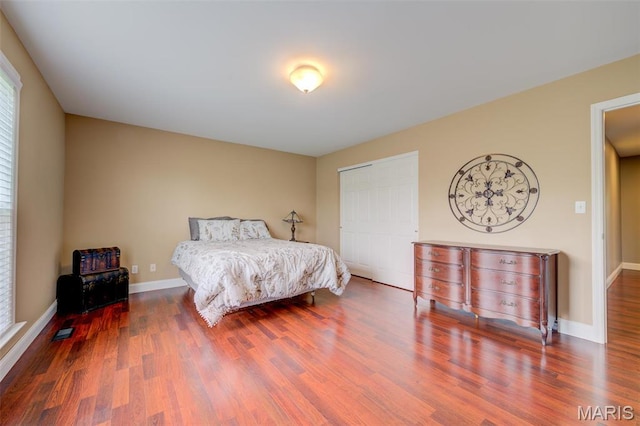 322 Gerard Ln, Moscow Mills, MO 63362 - bedroom with wood finished floors, a closet, baseboards, and multiple windows