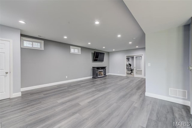 322 Gerard Ln, Moscow Mills, MO 63362 - unfurnished living room with wood finished floors, baseboards, recessed lighting, and a wood stove