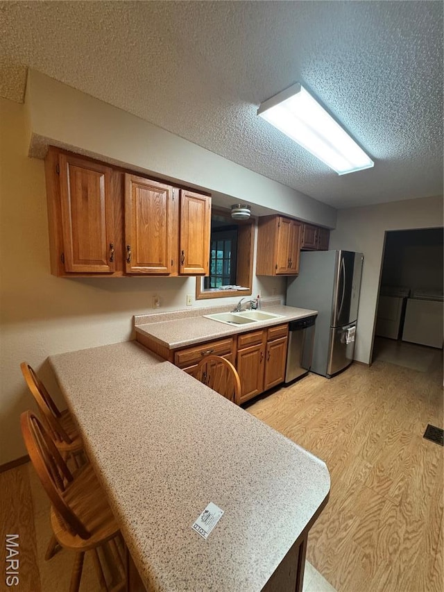 423 Rice Rd, Bonne Terre, MO 63628 - kitchen with stainless steel appliances, a sink, light countertops, a peninsula, and brown cabinets