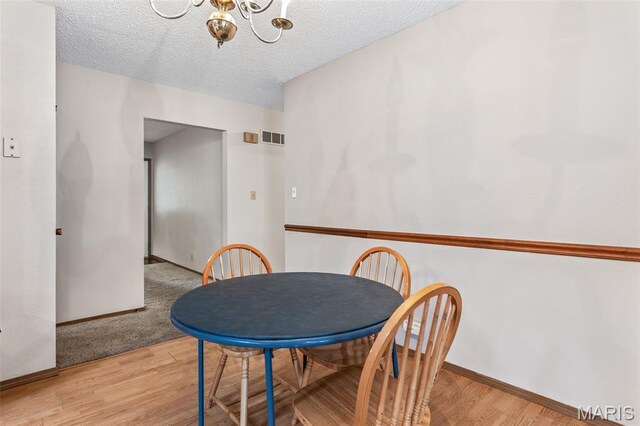 423 Rice Rd, Bonne Terre, MO 63628 - dining area with a chandelier, wood finished floors, baseboards, and a textured ceiling