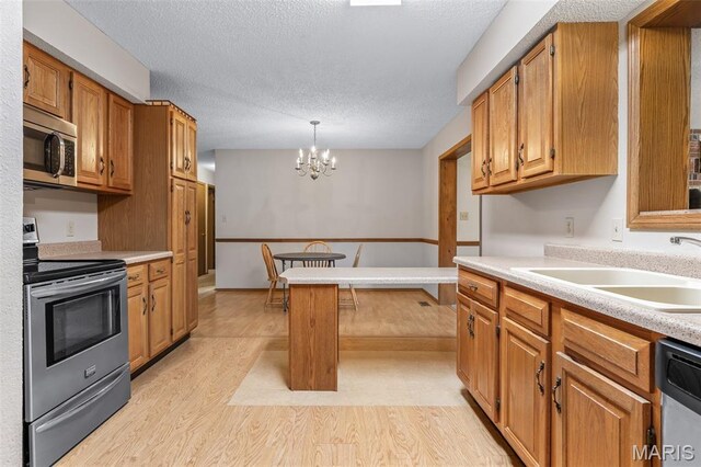 423 Rice Rd, Bonne Terre, MO 63628 - kitchen featuring appliances with stainless steel finishes, light wood finished floors, a sink, a chandelier, and light countertops