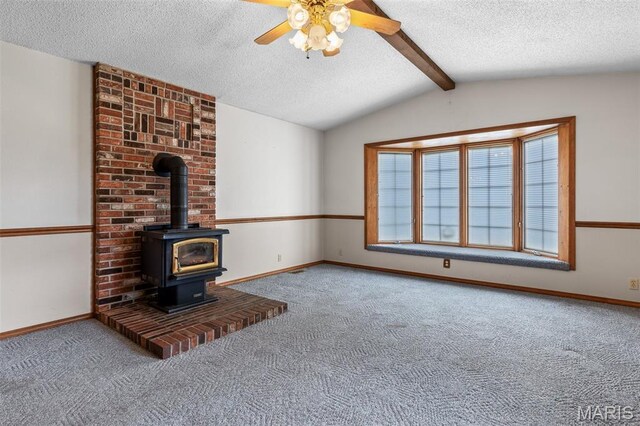 423 Rice Rd, Bonne Terre, MO 63628 - unfurnished living room with carpet flooring, a textured ceiling, ceiling fan, a wood stove, and baseboards